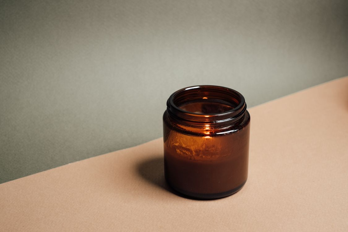 Stock preview photo of a candle in a warm brown glass jar
